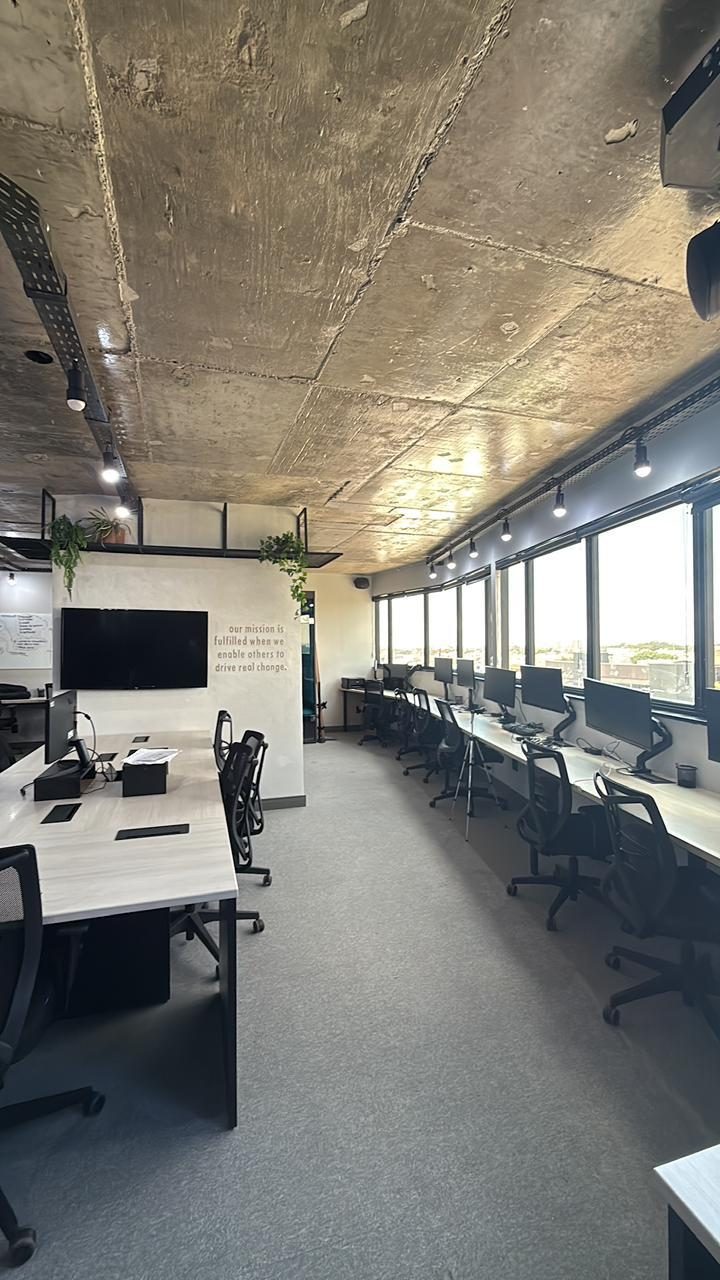 Estações de trabalho com monitor ultrawide ao lado das janelas